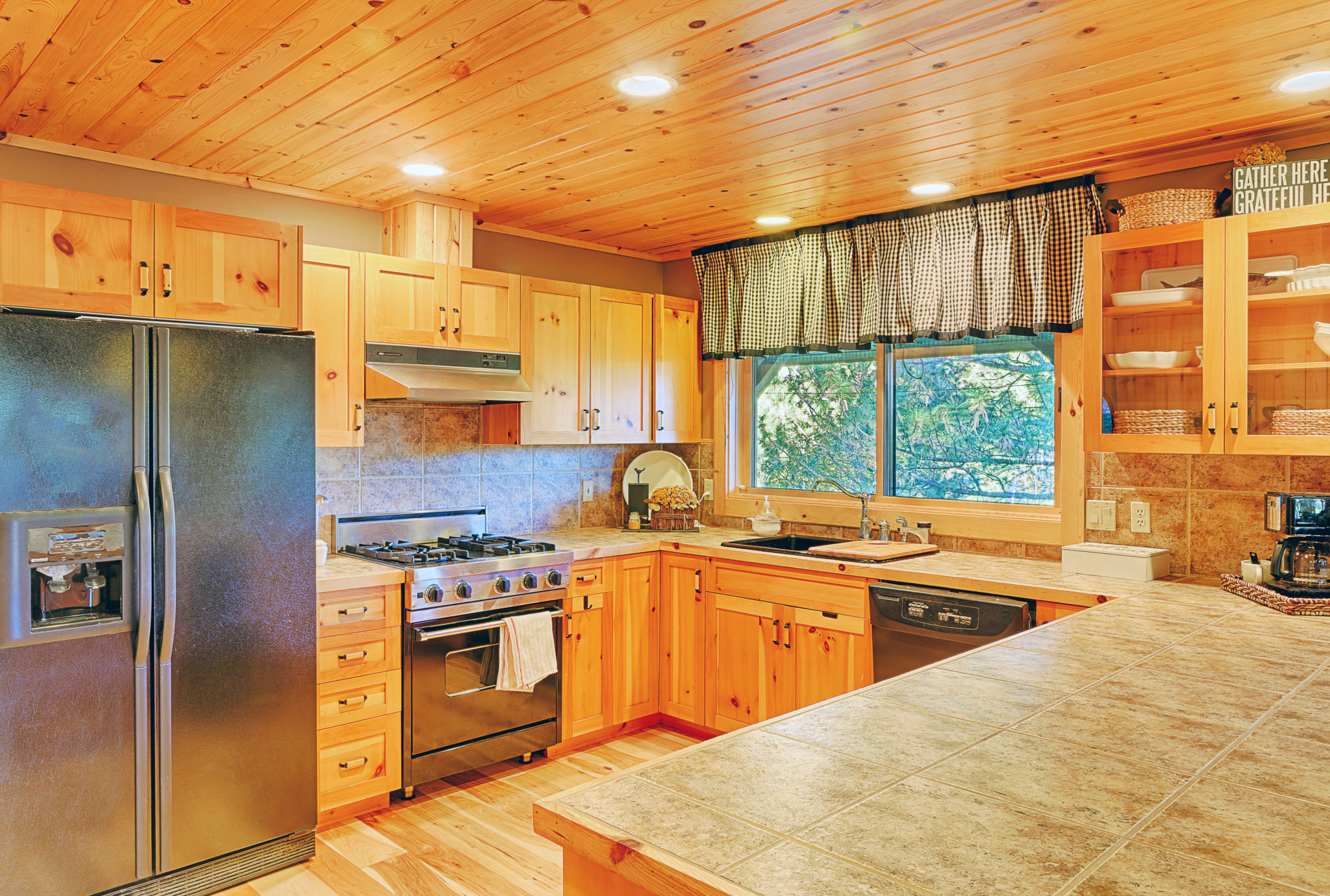 Warm wood kitchen cabinets with stone countertops